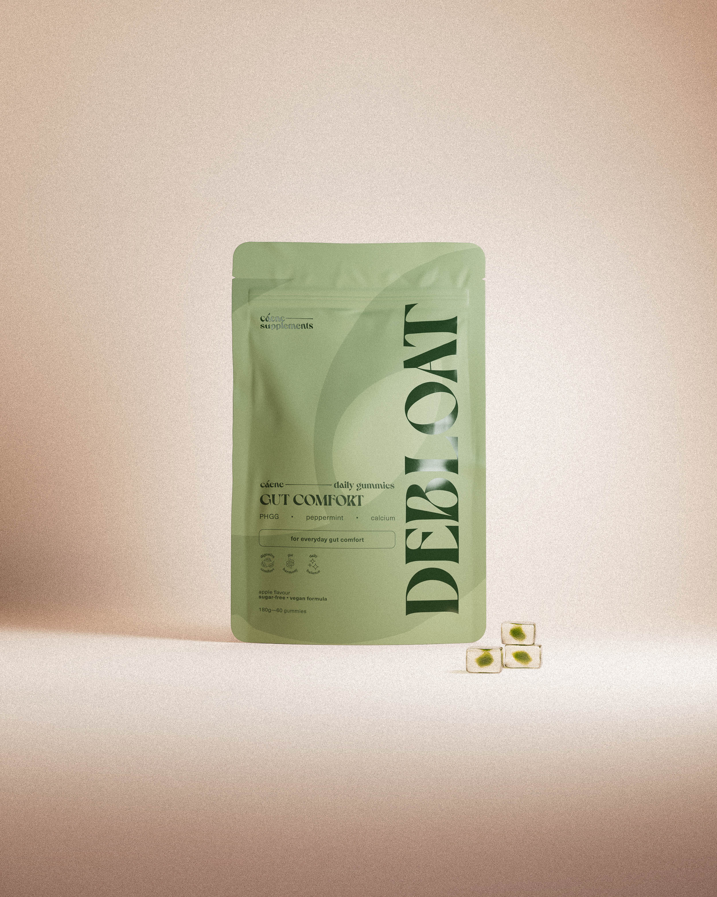 debloat gummies pouch with three green gummies in a warm studio setting